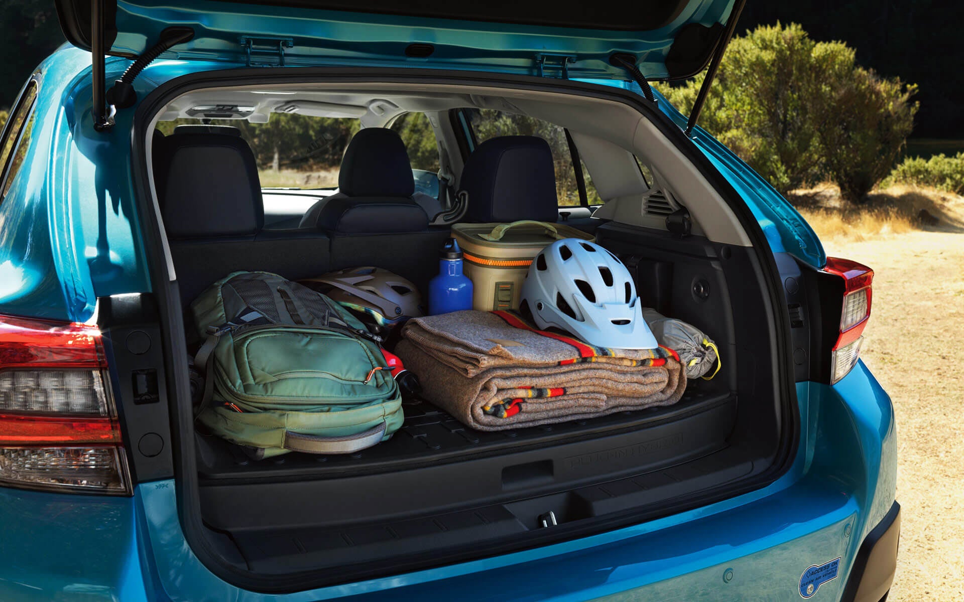 A backpack, blanket, and bike helmet in the rear cargo area of a Crosstrek Hybrid | Sierra Subaru of Monrovia in Monrovia CA
